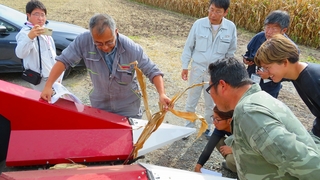 村中氏から収穫機の説明に興味を持つ受講生たち