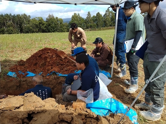 土壌の状況を確認する重点地域の農業者(写真中央後方）