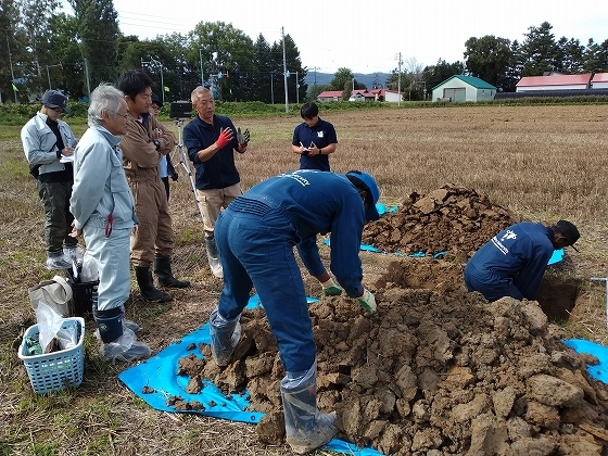 土壌の状況説明を外部講師（写真左から4人目）受ける農業者(写真左より3人目）